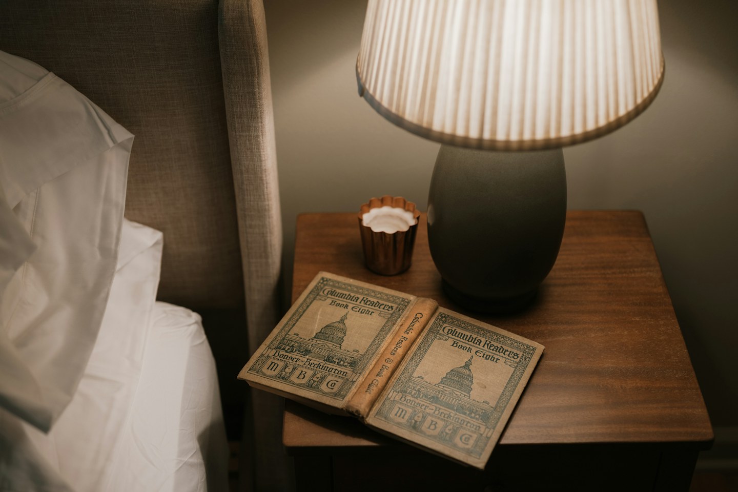 A warm bedside lamp beside a book